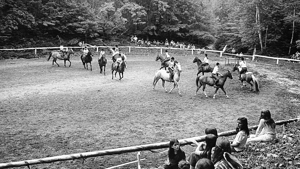 Black and white photo of campers horseback riding in 1978