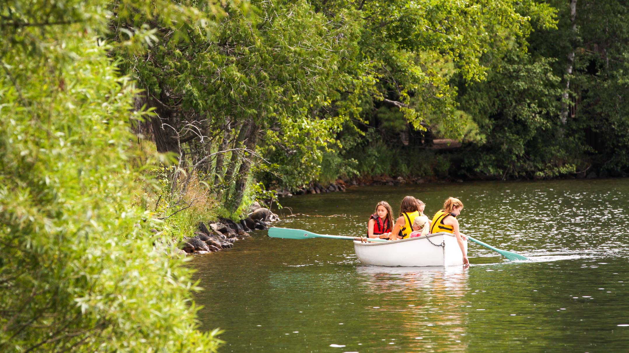 Campers paddle canoe along Clearwater shoreline