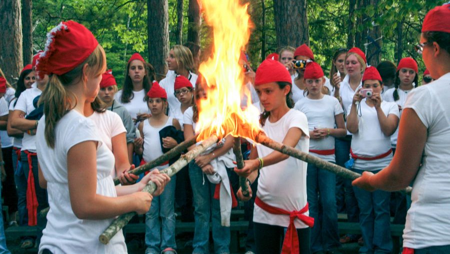 Campers hold torches together at Council Fire event