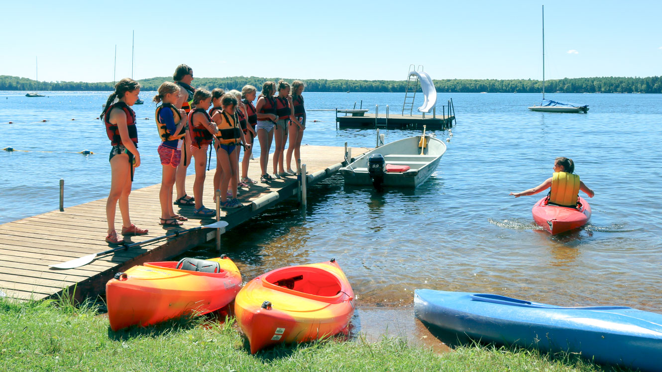 Campers line up on dock to learn kayak safety