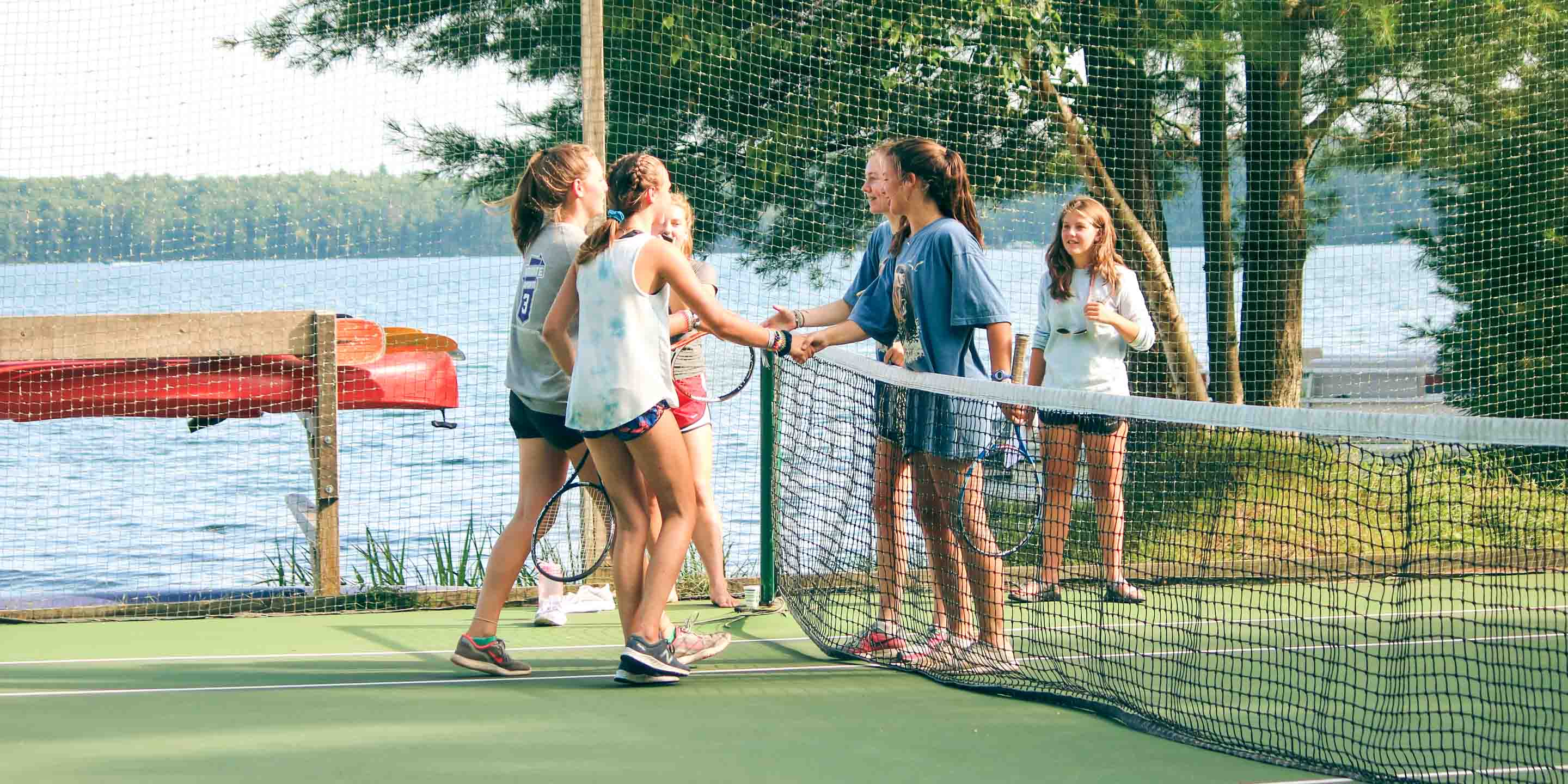 Campers shake hands after tennis match