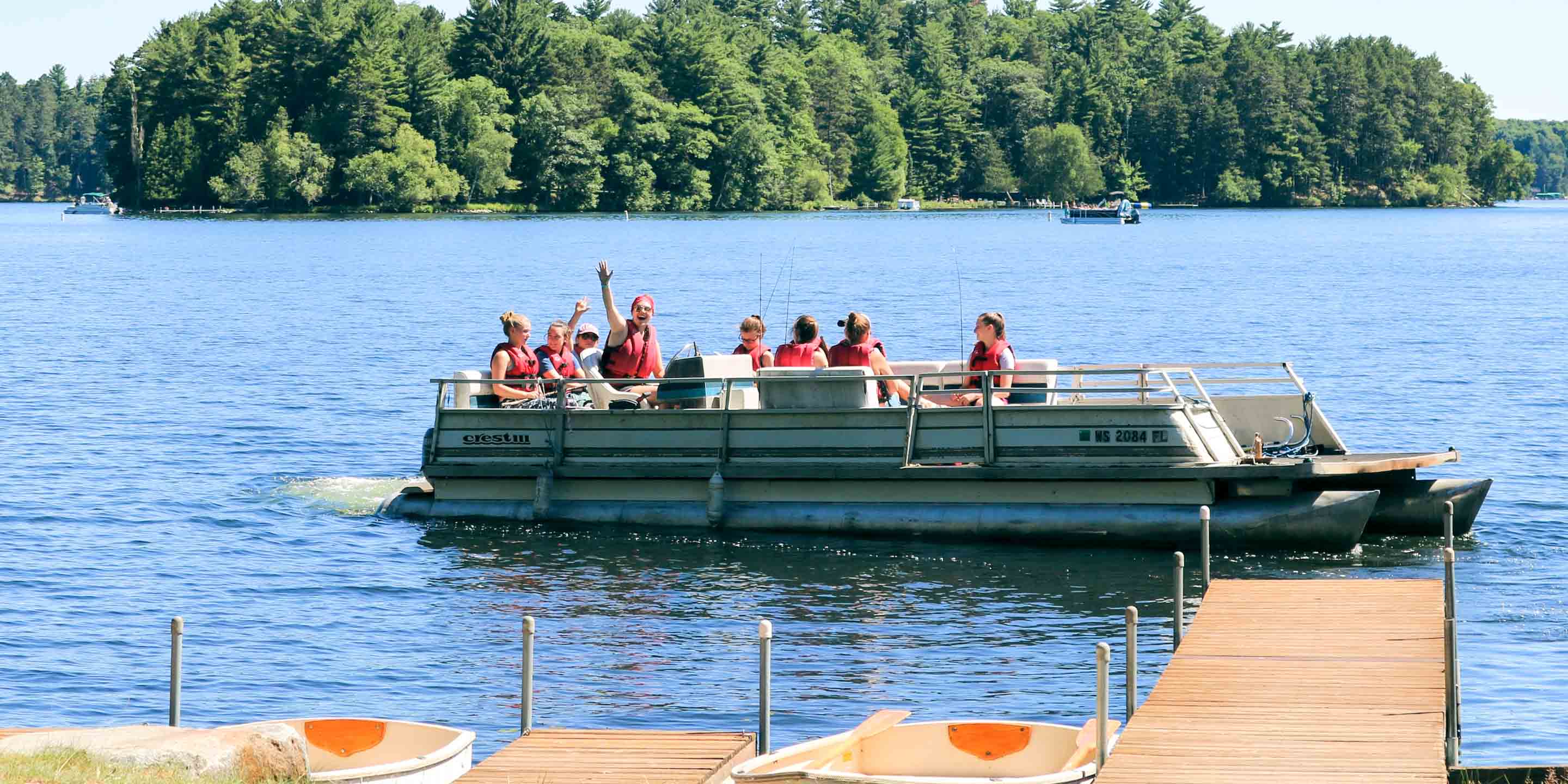 Group of campers waves from fishing boat
