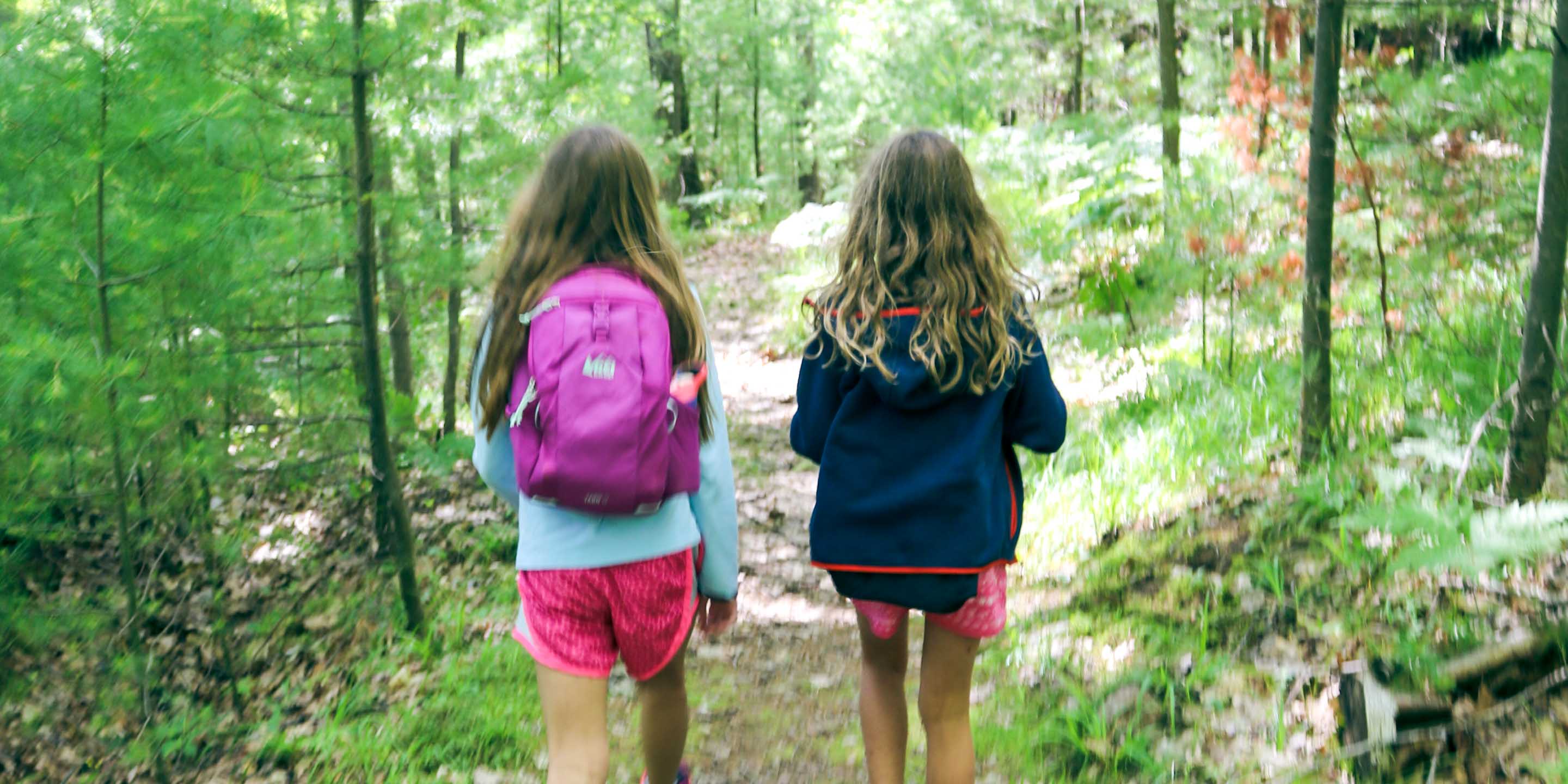 Young campers walk down trail on day hike