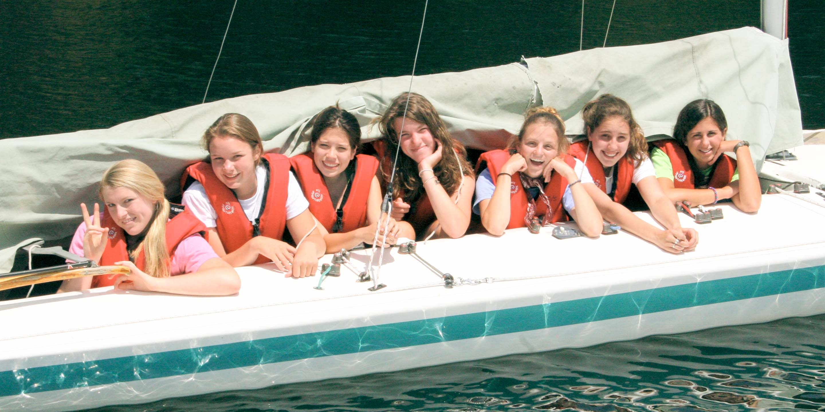 Campers lined up in boat smile toward camera