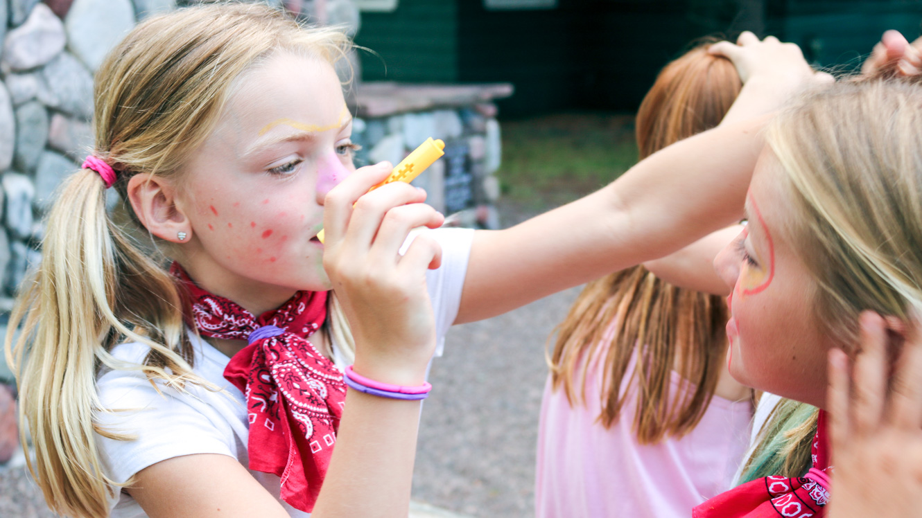 Campers paint each other's faces at Harbor Carnival