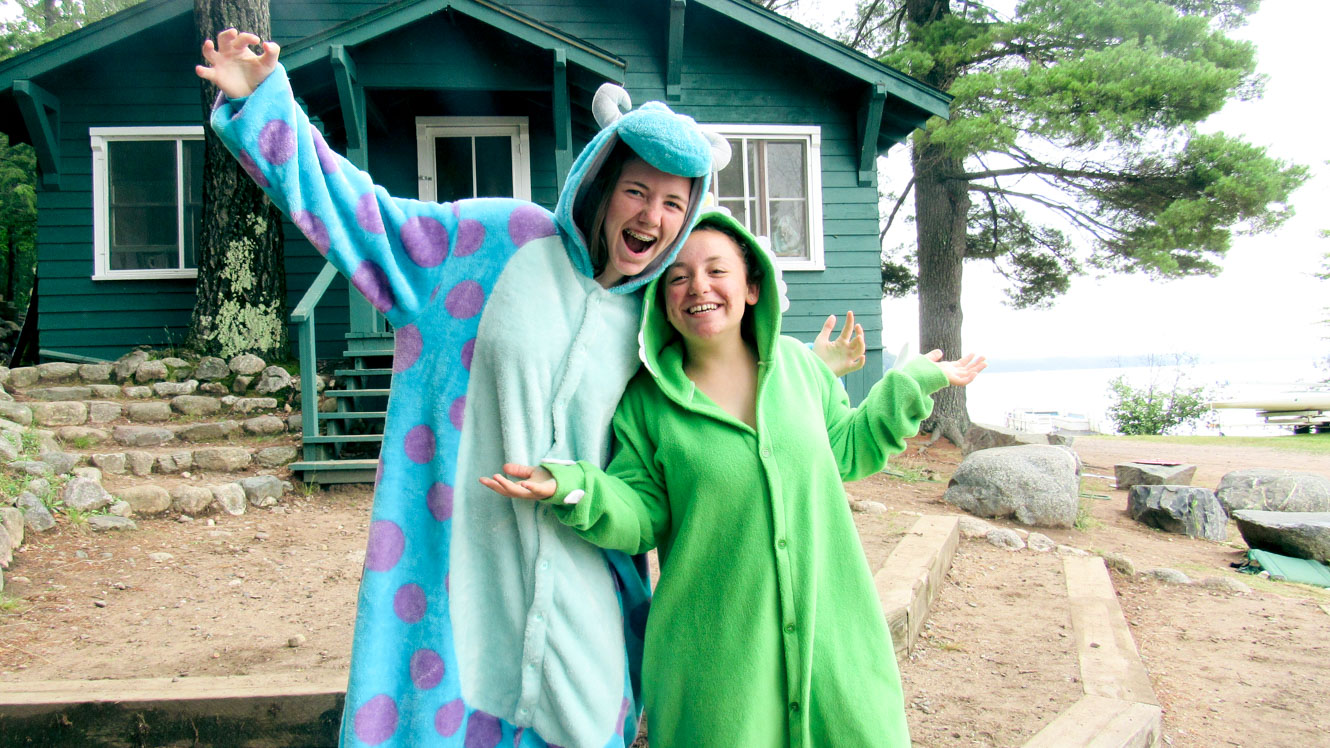 Young women look excited while wearing monster onesies